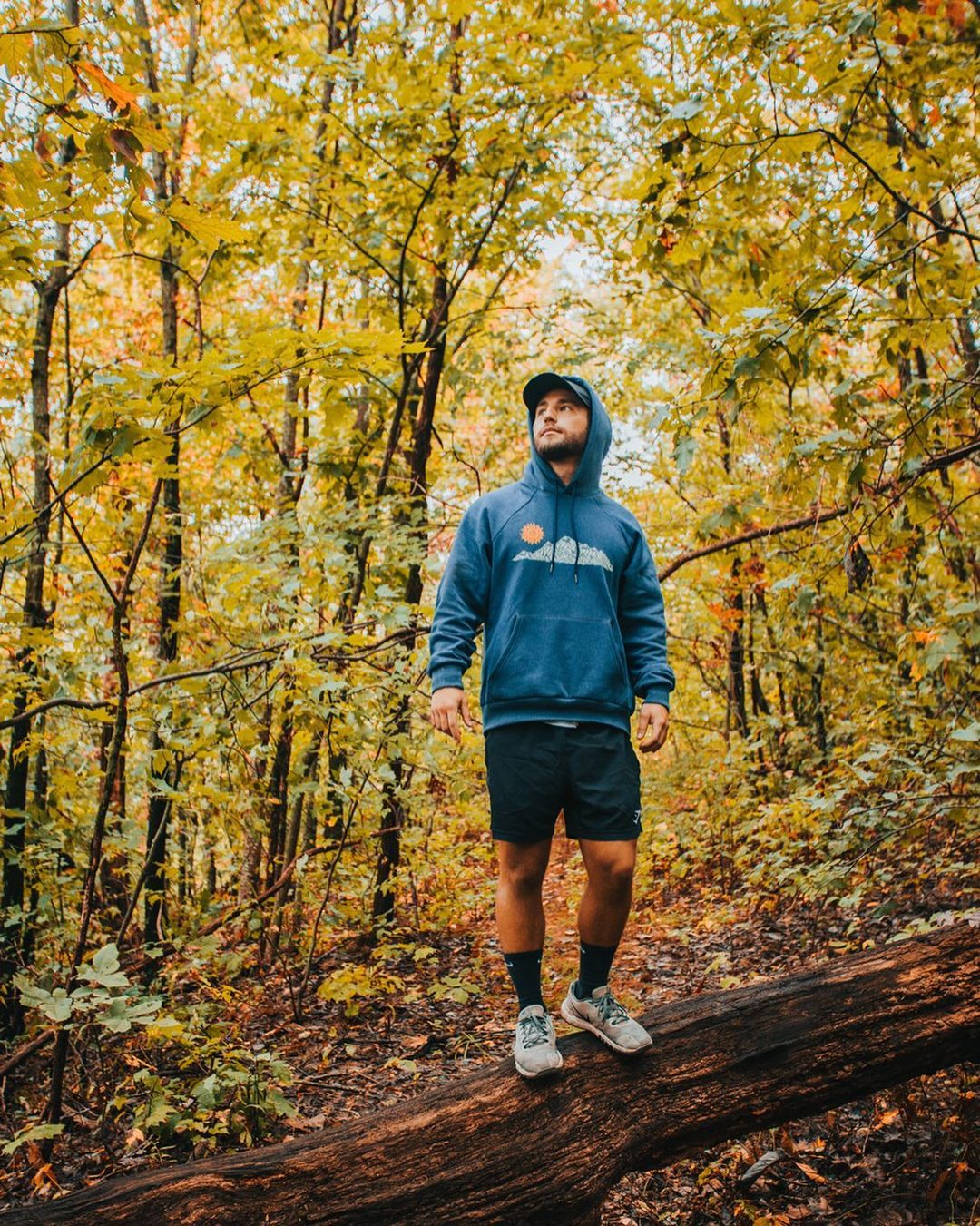 Person wearing tranquility hoodie in the woods 