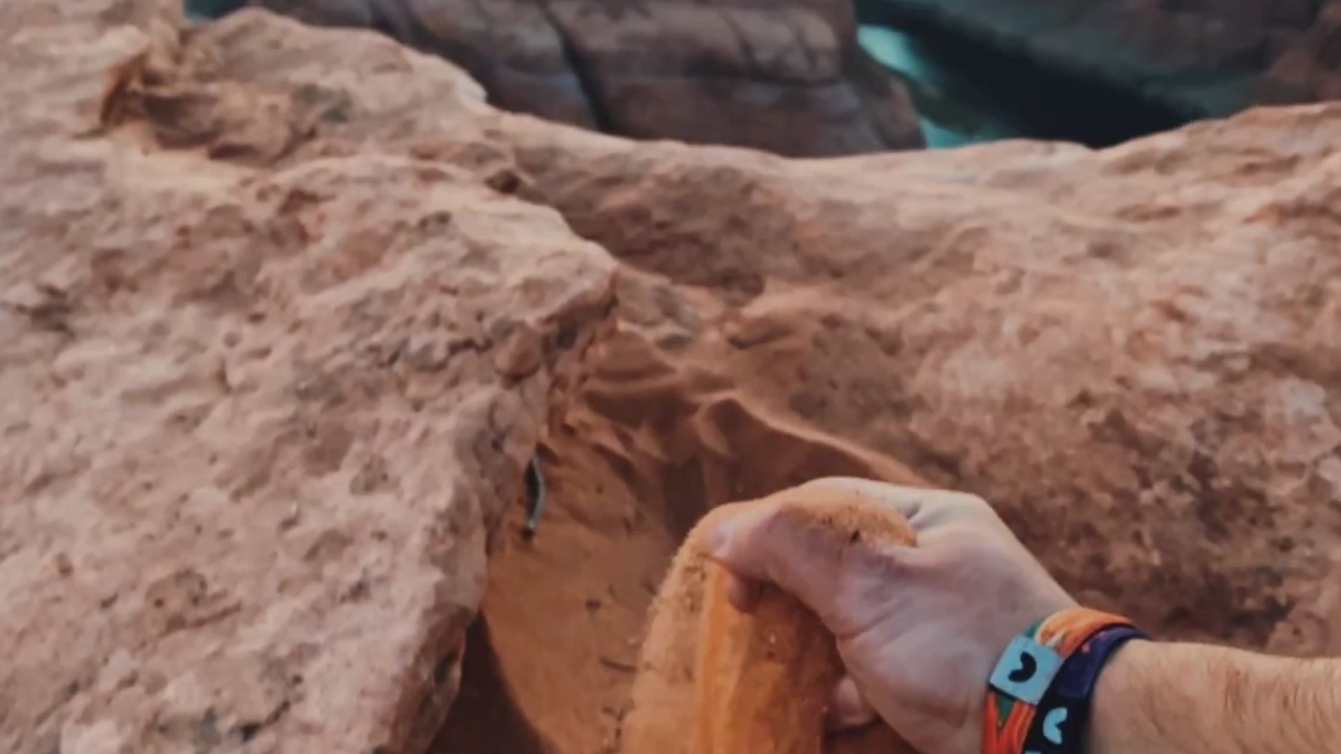 Adventure Bracelets being worn while dumping sand over horseshoe bend